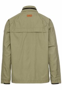Olive green, long-sleeved jacket with a front zip and buttoned collar, featuring stitching details and a leather brand patch on the back.