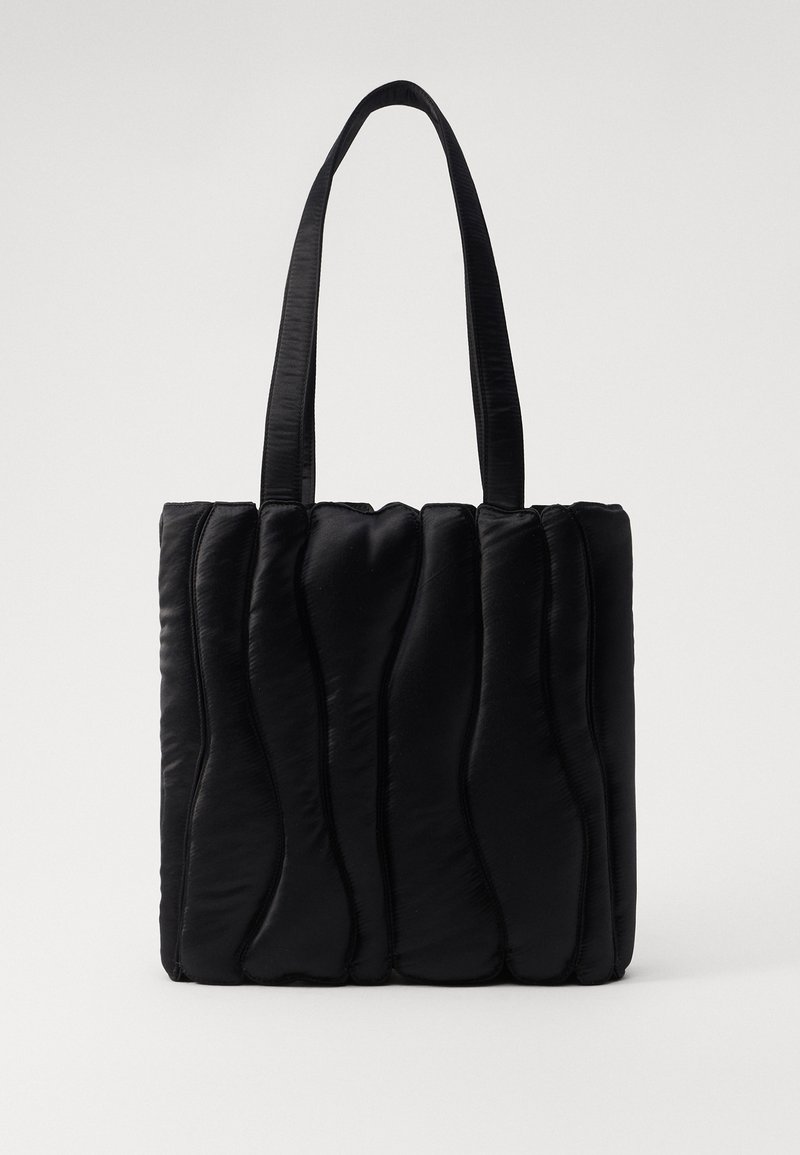 Czarna torba na ramię wykonana z wyściełanego materiału, z falistą fakturą, dwoma mocnymi uchwytami i prostokątnym kształtem. Prosty, nowoczesny design.