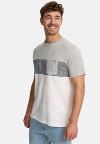 Herre t-shirt med en lys grå overdel, en marineblå stribet sektion og en hvid underdel. Indeholder en lille brystlomme.