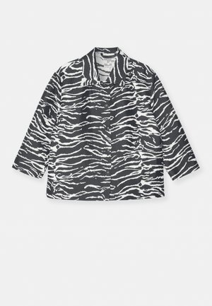 Veste à rayures zébrées noir et blanc avec un col, fermeture à boutons et manches longues, fabriquée dans un tissu texturé.