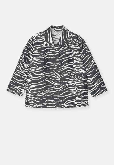 Casaco riscado de zebra em preto e branco com gola, fecho de botões na frente e mangas longas, feito de um tecido texturizado.