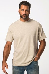 T-shirt in cotone beige con collo rotondo, maniche corte, vestibilità comoda e un logo discreto sul petto, abbinato a jeans in denim blu.
