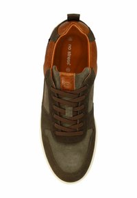 Bruine en groene sneaker met een gevarieerde bruine leren hak, voorzien van bruine veters en een witte rubberen zool, gelabeld "geen stress."