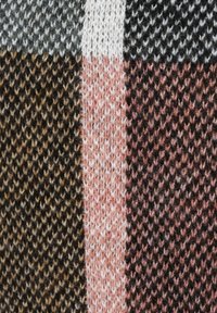 Gros plan sur un tissu tricoté avec des rayures verticales en gris, marron, blanc, rose et noir, montrant la texture détaillée des points.