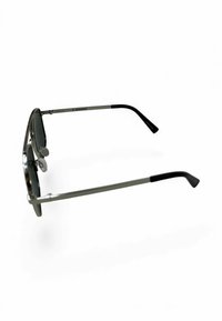 Okulary przeciwsłoneczne z metalową, srebrną oprawką, prostokątnymi soczewkami, czarnymi końcówkami zauszników i regulowanymi noskami. Charakteryzują się minimalistycznym designem.