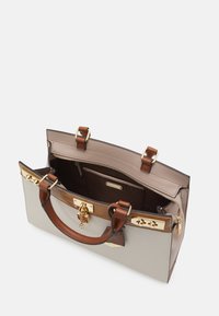 Sac à main au design structuré, avec un extérieur beige, des accents en cuir brun, une quincaillerie dorée, et une ouverture supérieure dévoilant des poches intérieures.