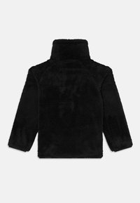 Svart fleecejacka med hög krage, texturerat, mjukt material. Har långa raglansärmar och en kortad fåll. Ingen synlig hårdvara.