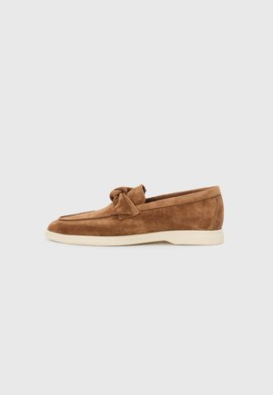 Mocassins de camurça castanhos com um detalhe de laço atado, um design de perfil baixo e uma sola de borracha creme contrastante.