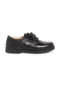 Chaussure en cuir noir avec une surface lisse, un bout rond et une sangle velcro. Talon bas et semelle en caoutchouc texturée pour la stabilité.