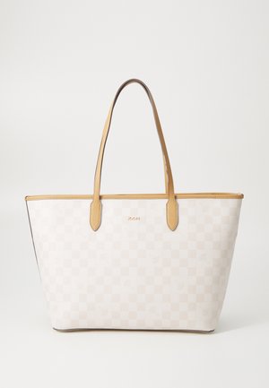 Witte geruite tas met tan lederen hengsels en accenten, heeft een logo in het midden, een gladde textuur en een open ontwerp.