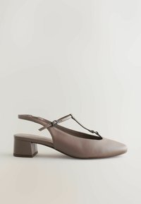 Chaussure à talon haut avec bride arrière en taupe. Caractéristiques : bout pointu, dessus en cuir lisse, design à bride en T, talon carré. Accents métalliques subtils.