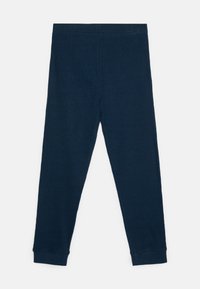 Marineblauwe legging gemaakt van zachte, rekbare stof. Kenmerkt zich door een aansluitend ontwerp met een naadloze taille en taps toelopende enkels. Geen zichtbare patronen of accenten.