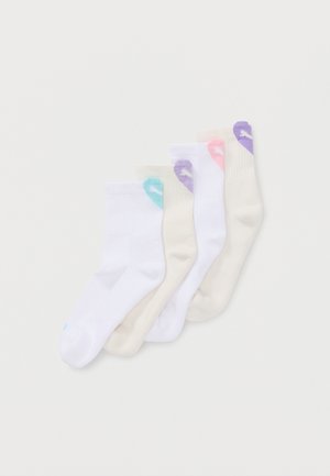 Quatre paires de socquettes blanches et beiges avec le logo Puma en bleu, rose et violet près du bord supérieur, disposées en diagonale sur un fond blanc.