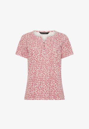 Biała koszula z krótkim rękawem w czerwony kwiatowy wzór, okrągły dekolt z małym wycięciem w kształcie litery V i cztery guziki na przedniej listwie.