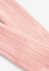 Texturovaná růžová pletenina, která se vyznačuje horizontálními a vertikálními žebrovanými vzory s jemnými detaily po celém povrchu, měkká a lehká.