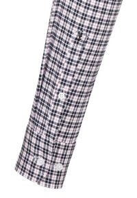 Polsino della camicia a maniche lunghe con un motivo a quadretti nero, bianco e rosso e due bottoni bianchi sul polsino e uno sulla patta della manica.