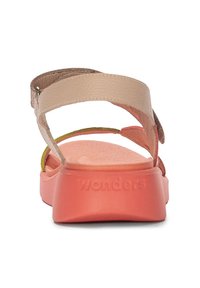 Sandal rosa y beige con una tira texturizada, hebilla ajustable y una suela ancha y acolchada con la marca "wonders" grabada.