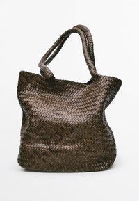 Hnědá pletená taška s měkkým, texturovaným povrchem a dvěma uchy, s otevřeným vrchem a zaoblenými okraji pro neformální design.