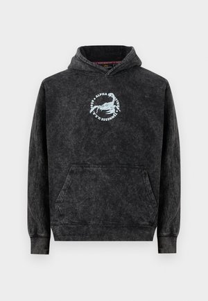 Sweat à capuche noir délavé avec poche kangourou à l'avant, arborant un logo de scorpion blanc et le texte "Alpha Industries Tennessee U.S.A." sur la poitrine.