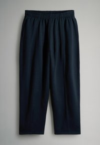 Tmavě modré sportovní kalhoty vyrobené z měkkého materiálu, s elastickým páskem a zúženými nohavicemi se bočními švy pro lepší definici.