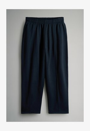 Ciemnoniebieskie spodnie sportowe wykonane z miękkiego materiału, z elastycznym pasem i zwężanymi nogawkami z przeszyciami bocznymi dla lepszego dopasowania.