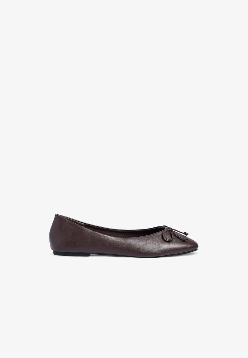Brown leather ballet flat with a rounded toe, featuring a bow accent and a smooth texture. Flat sole for easy wear.