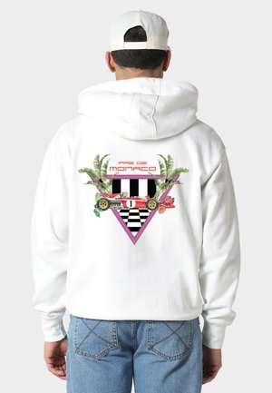 Haut à capuche blanc avec un graphisme coloré au dos, comprenant un motif à carreaux, des feuilles tropicales et une voiture de course rouge dans un triangle.