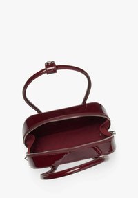 Bordeaux leren handtas van patenter, met een glanzende afwerking; beschikt over een ritssluiting, een enkele handgreep en een ruime, met stof voering interieur.