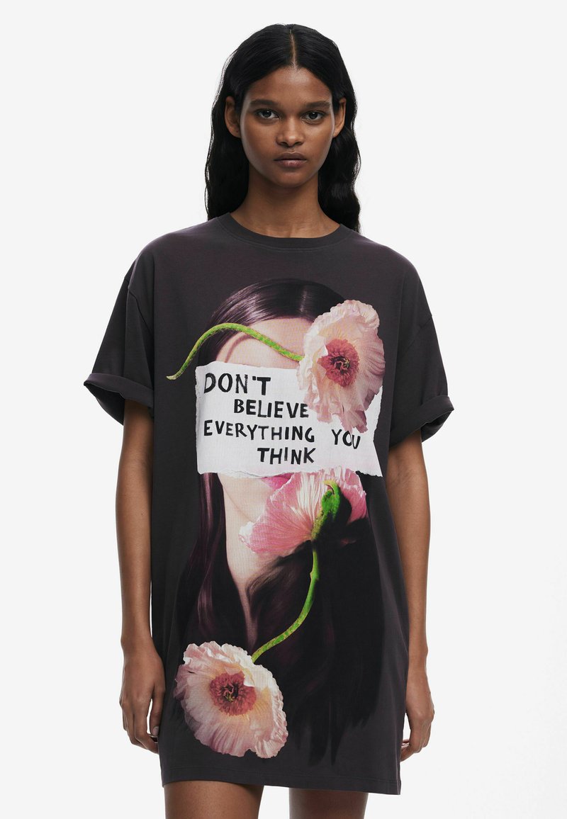 Musta suur t-särk, millel on graafiline kujundus naise näost koos roosa lilledega ning tekst "ÄRGE USU KÕIKE, MIDA TE KUIDAGI MÕTLETE."