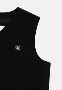 Gilet sans manches noir avec un design en V, fabriqué dans un matériau lisse. Présente un petit logo CK dans un patch carré à l'avant.