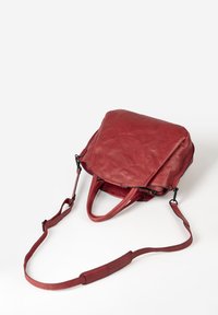 Borsa in pelle rossa con una forma strutturata, manici superiori e una tracolla regolabile. Texture liscia e design minimalista.
