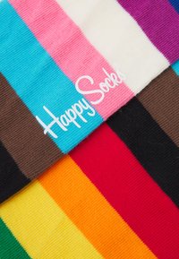 Chaussettes rayées colorées présentant des motifs bleus, roses, blancs, marron, noirs, rouges, orange, jaunes et verts avec le logo "Happy Socks".