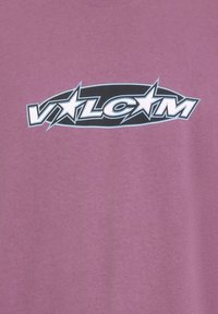 T-shirt violet à manches courtes avec un logo circulaire noir contenant "VLCM" en blanc et bleu clair, avec des accents d'étoiles.