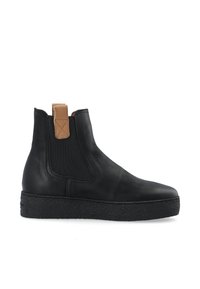 Bottines noires en cuir avec panneaux élastiques sur les côtés, bout rond et semelle en caoutchouc noir texturé. Dotées d'une languette beige à l'arrière.