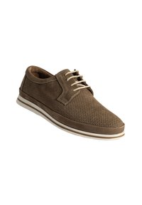 Chaussure en suède brun perforée avec un bout rond, lacets beiges et une semelle en caoutchouc blanche dotée d'une fine bande de couleur brune.