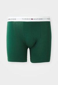 Dunkelgrüne Herren-Boxershorts mit einem weißen Bund, der das Tommy Hilfiger-Logo und das Flaggenemblem zeigt.