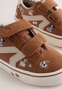 Baskets enfants marron avec broderie de chien et empreintes de pattes, accents en suédine beige et deux bandes velcro réglables.