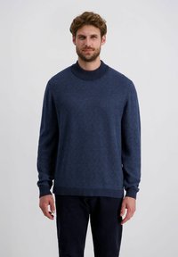 Marineblauer Pullover mit hohem Kragen und einem strukturierten Rautenmuster. Rippbündchen und Saum, aus einem weichen Strickmaterial gefertigt.