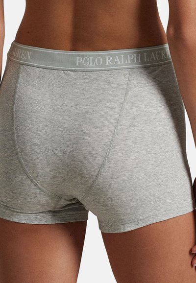 Κοντινό πλάνο ενός ατόμου που φοράει ανοιχτό γκρι μπόξερ με λάστιχο στη μέση με το λογότυπο "Polo Ralph Lauren".