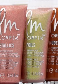 Tre rør med flytende pigment: glinsende metallisk rosa, glittergrønn og metallisk nudeskygge. Hver etikett har detaljer om vanntett bruk.