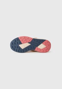 Semelle d'une chaussure beige avec un motif de semelle texturé en bleu marine, rose et beige, arborant le nom de la marque "remo" embossé au centre.
