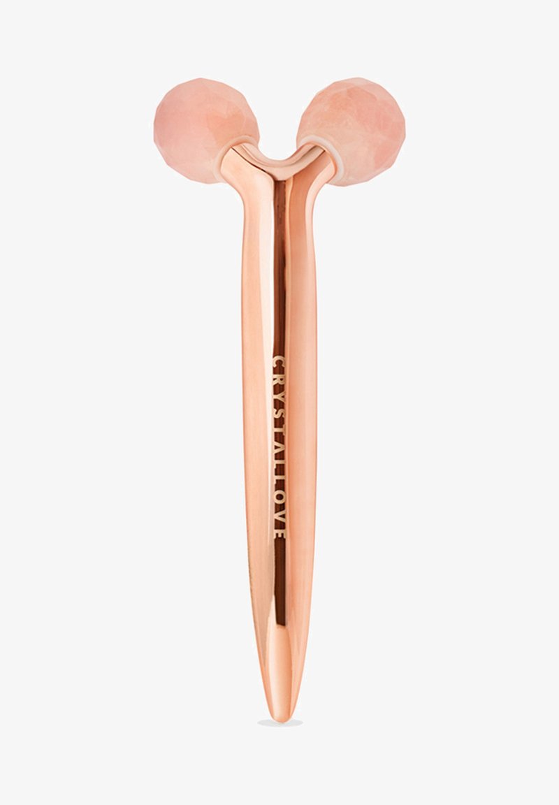 Rosenquarz-Gesichtsroller mit zwei facettierten rosafarbenen Steinkugeln an einem polierten Roségoldgriff. Mit dem eingravierten Schriftzug "CRYSTALLOVE" auf dem Griff.