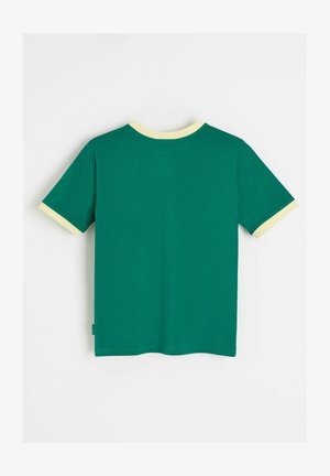 Zielona koszulka z krótkim rękawem z jasnżółtym kołnierzem i mankietami na rękawach, pokazana od tyłu na białym tle.