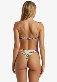Blommig bikinitopp och botten med en lila bakgrund och färgglada blommönster, justerbara band och en guldfärgad spänne på toppen.