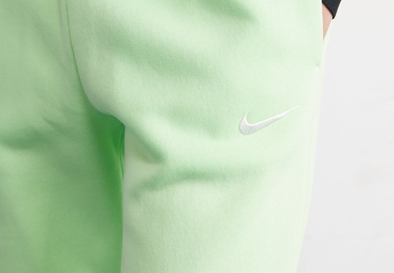 Hellgrüne Nike-Sweatpants besitzen eine weiche Textur, einen elastischen Bund, seitliche Taschen und ein weiß gesticktes Logo am linken Oberschenkel.