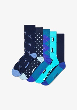 Set of five socks featuring blue, navy, and teal colors with patterns: giraffes, polka dots, argyle, and penguins; cotton material.