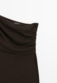 Donkerbruin off-shoulder top met gerimpelde details aan het bovenste gedeelte en een zichtbare Massimo Dutti-label bij de halslijn.