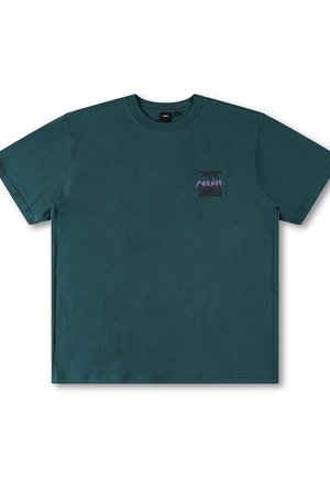 Camiseta de algodón color teal con cuello redondo y mangas cortas. Presenta un pequeño logo gráfico en color púrpura en la parte superior izquierda del pecho.