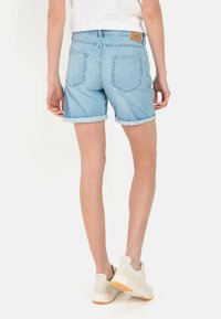 Lichtblauwe denimshorts met omgeslagen zoom en hoge taille. Bevat twee achterzakken en een tan leren label op de tailleband.
