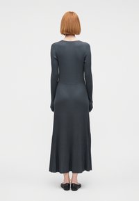 Φόρεμα με μακριά μανίκια από ριμπ ύφασμα σε σκούρο γκρι, στενή γραμμή στο μπούστο, φούστα σε σχήμα φούσκας, λεία υφή, μήκος μέχρι το γόνατο, με λεπτομέρεια σαλιγκαρισμένης άκρης.